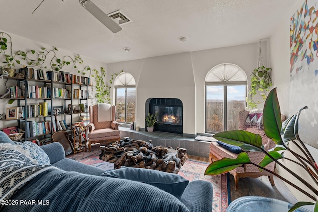 969 S Saguaro Dr, Wickenburg, AZ 85390 - living room featuring healthy amount of natural light, a fireplace, wood finished floors, and a textured ceiling
