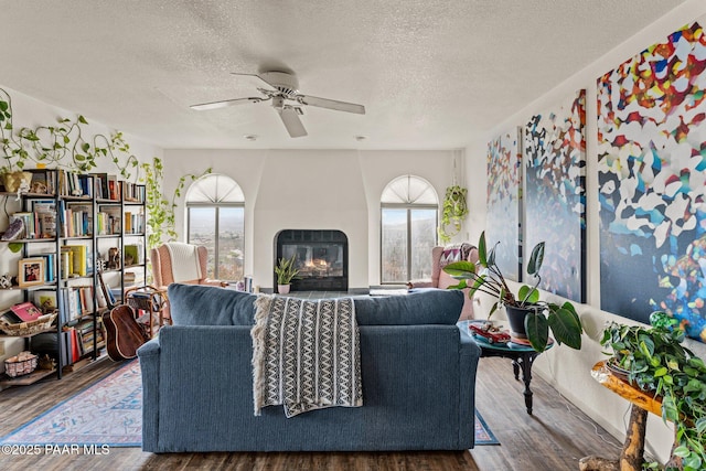 969 S Saguaro Dr, Wickenburg, AZ 85390 - living room with healthy amount of natural light, wood finished floors, a textured ceiling, a fireplace, and ceiling fan