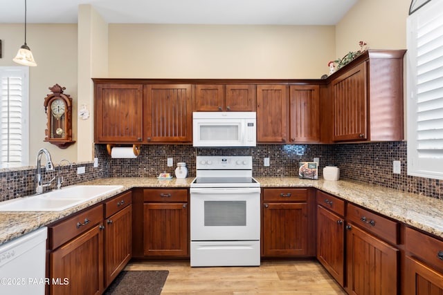 6237 E Boothwyn St, Prescott Valley, AZ 86314 - kitchen with white appliances, light wood-style flooring, backsplash, hanging light fixtures, and light stone countertops
