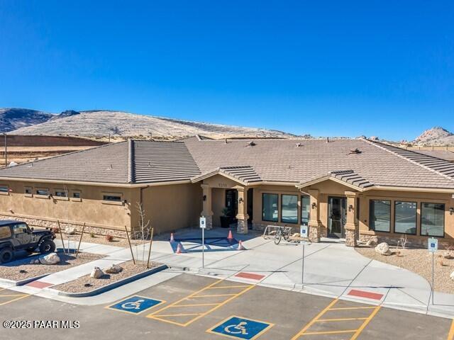 6237 E Boothwyn St, Prescott Valley, AZ 86314 - rear view of property featuring stucco siding, a tile roof, uncovered parking, a mountain view, and a patio