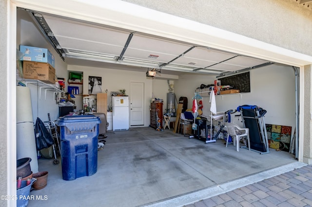 12993 E Toro St, Dewey-Humboldt, AZ 86327 - garage featuring freestanding refrigerator, a garage door opener, and gas water heater