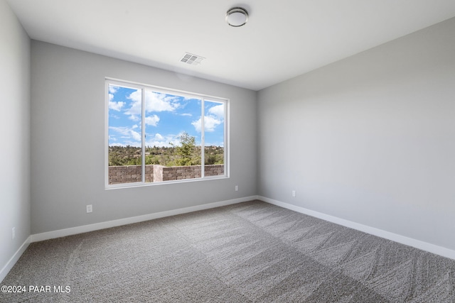 carpeted empty room featuring visible vents and baseboards