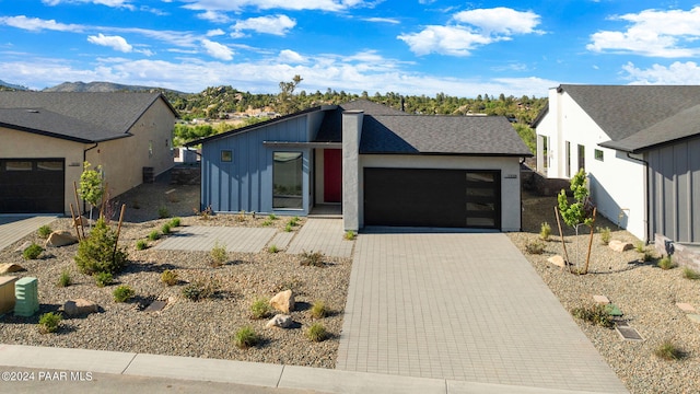 view of front of house with a garage, stucco siding, and driveway