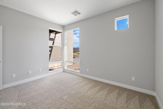 spare room featuring visible vents, baseboards, and carpet flooring