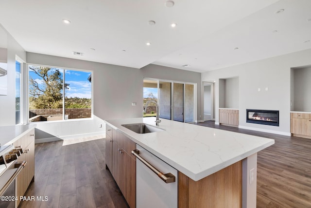 kitchen with white dishwasher, stove, modern cabinets, a sink, and a center island with sink