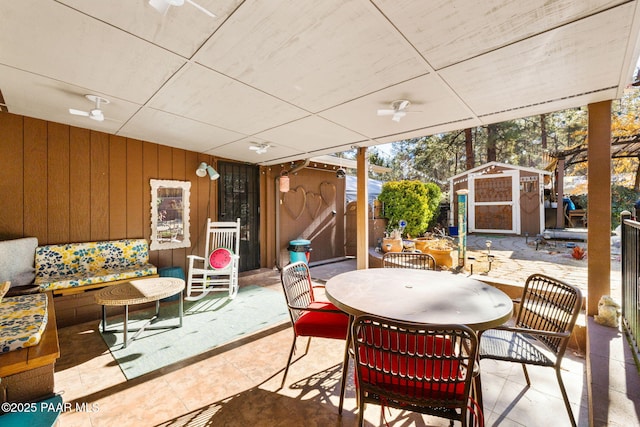 view of patio with ceiling fan and a storage unit