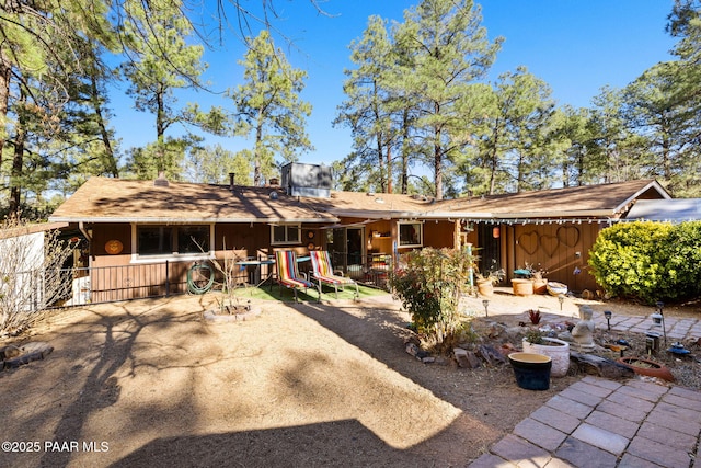 rear view of property with a playground and a patio