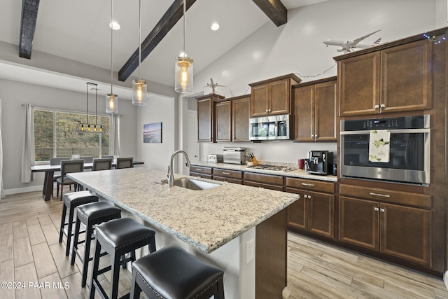 5109 Porter Creek Dr, Prescott, AZ 86301 - kitchen with stainless steel appliances, a sink, a kitchen breakfast bar, light stone counters, and an island with sink