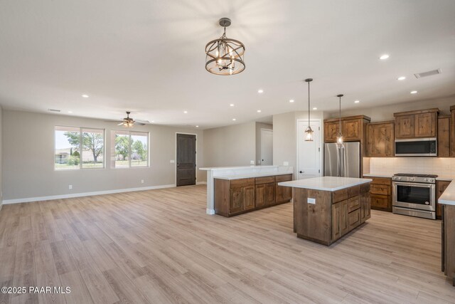 kitchen featuring appliances with stainless steel finishes, a center island, recessed lighting, tasteful backsplash, and light wood-style floors