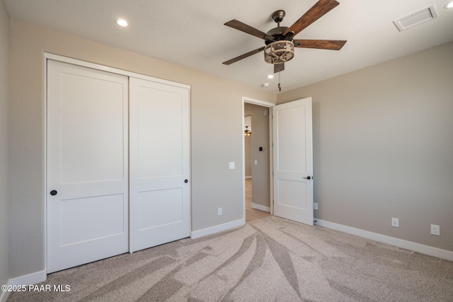unfurnished bedroom featuring recessed lighting, a closet, carpet, baseboards, and a ceiling fan