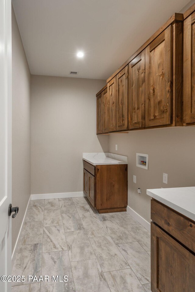 laundry area featuring cabinet space, washer hookup, baseboards, light marble finish floors, and hookup for a gas dryer