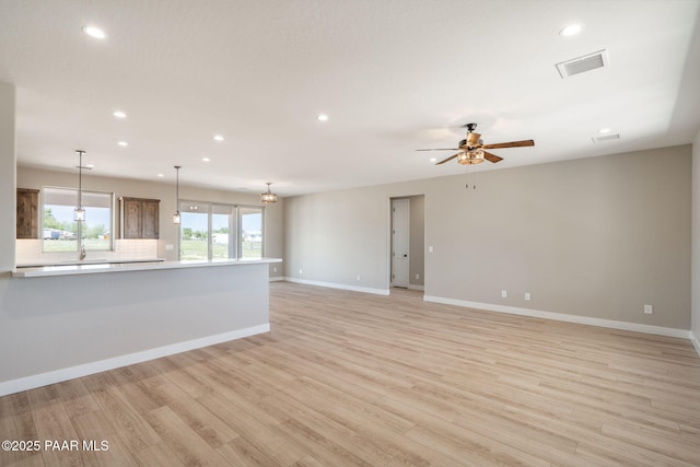 unfurnished living room with light wood finished floors, recessed lighting, ceiling fan, and baseboards