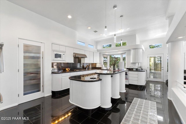 1369 Sierry Peaks Dr, Prescott, AZ 86305 - kitchen featuring a center island, dark countertops, recessed lighting, white cabinets, and a towering ceiling