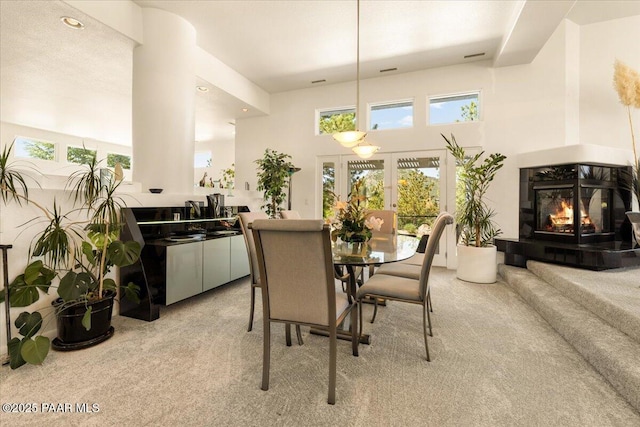 1369 Sierry Peaks Dr, Prescott, AZ 86305 - dining area with light carpet, a fireplace, and a towering ceiling