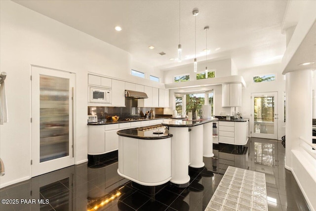 1369 Sierry Peaks Dr, Prescott, AZ 86305 - kitchen featuring a kitchen island, dark countertops, white cabinetry, recessed lighting, and a high ceiling