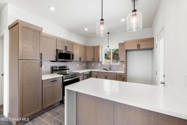1800 N Pearl Ln, Prescott, AZ 86301 - kitchen with stainless steel appliances, a peninsula, decorative backsplash, light countertops, and decorative light fixtures