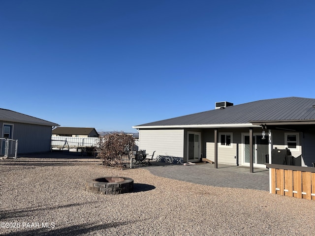 rear view of house featuring a patio area and a fire pit