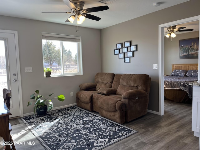 living room featuring wood-type flooring and ceiling fan