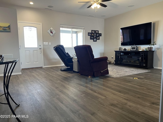 living room with dark wood-type flooring, plenty of natural light, and ceiling fan