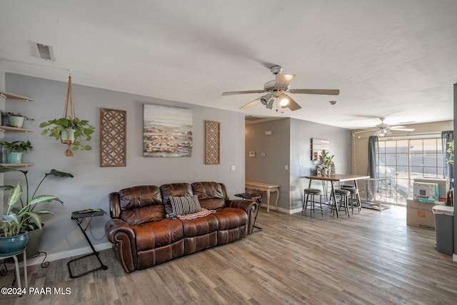 living room featuring ceiling fan and wood-type flooring