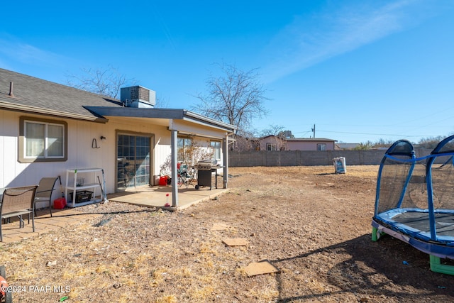 view of yard with central AC, a patio, and a trampoline