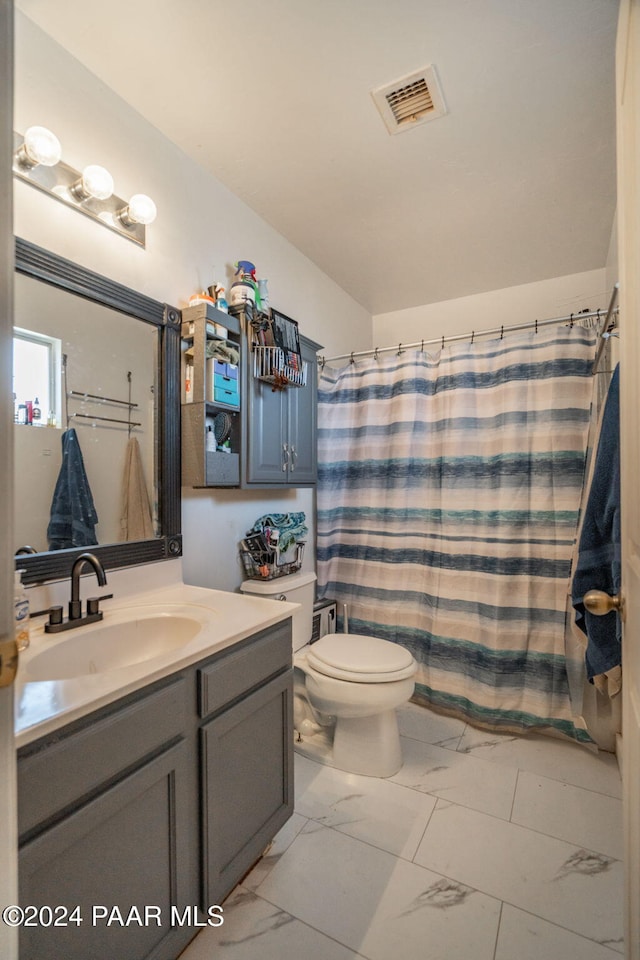 bathroom with curtained shower, vanity, and toilet