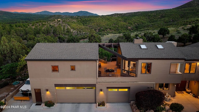 1301 S Manzanita Hill Rd, Prescott, AZ 86303 - view of front facade featuring a balcony, a chimney, a mountain view, driveway, and an attached garage