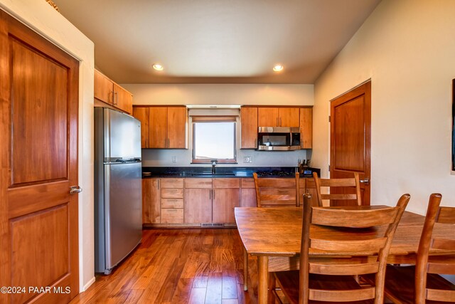 1301 S Manzanita Hill Rd, Prescott, AZ 86303 - kitchen with brown cabinetry, a sink, dark countertops, stainless steel appliances, and dark wood-style floors