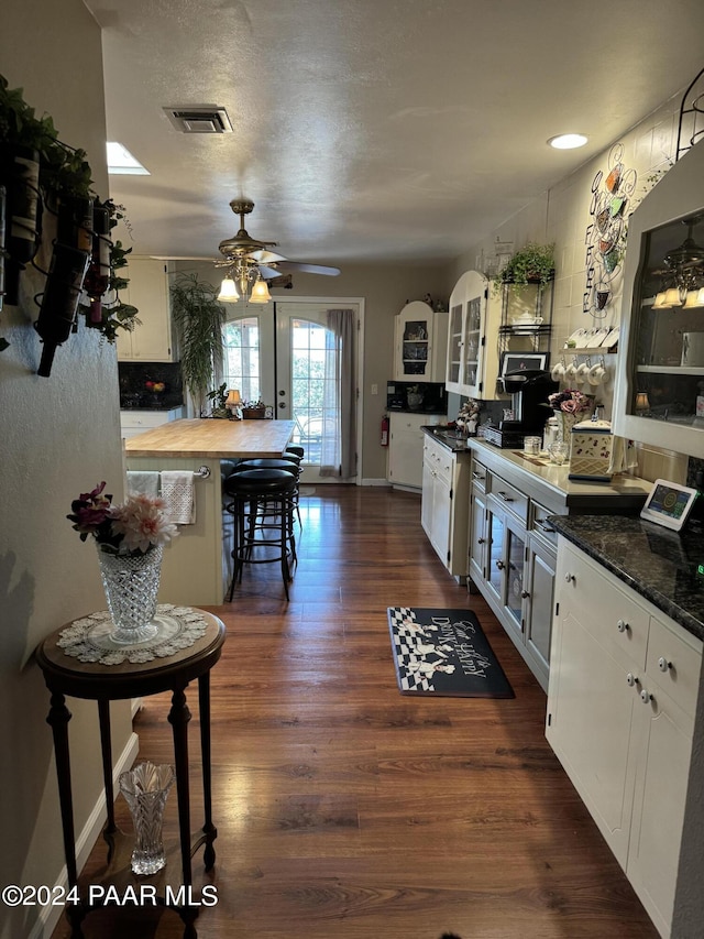 kitchen featuring a textured ceiling, ceiling fan, white cabinets, and dark hardwood / wood-style floors