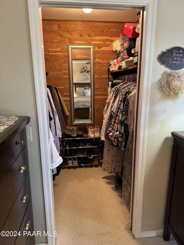 walk in closet featuring light colored carpet