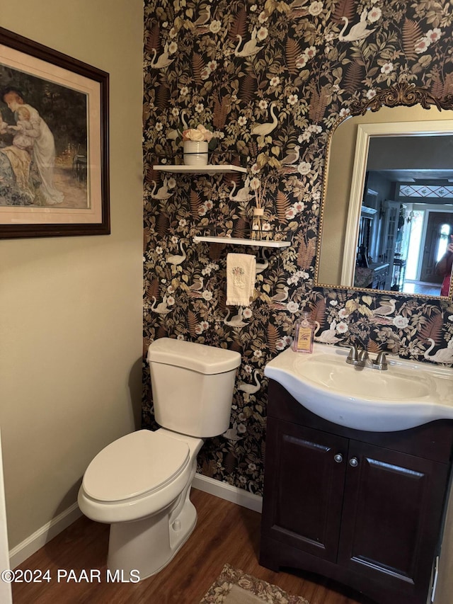 bathroom with hardwood / wood-style floors, vanity, and toilet