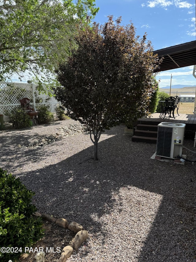 view of yard featuring central air condition unit and a deck