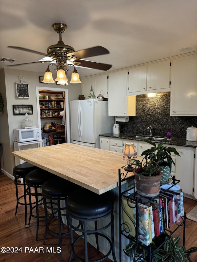 kitchen with white appliances, white cabinets, sink, dark hardwood / wood-style floors, and ceiling fan