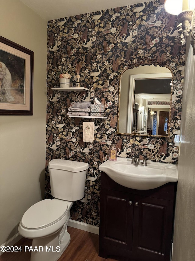 bathroom with wood-type flooring, vanity, and toilet