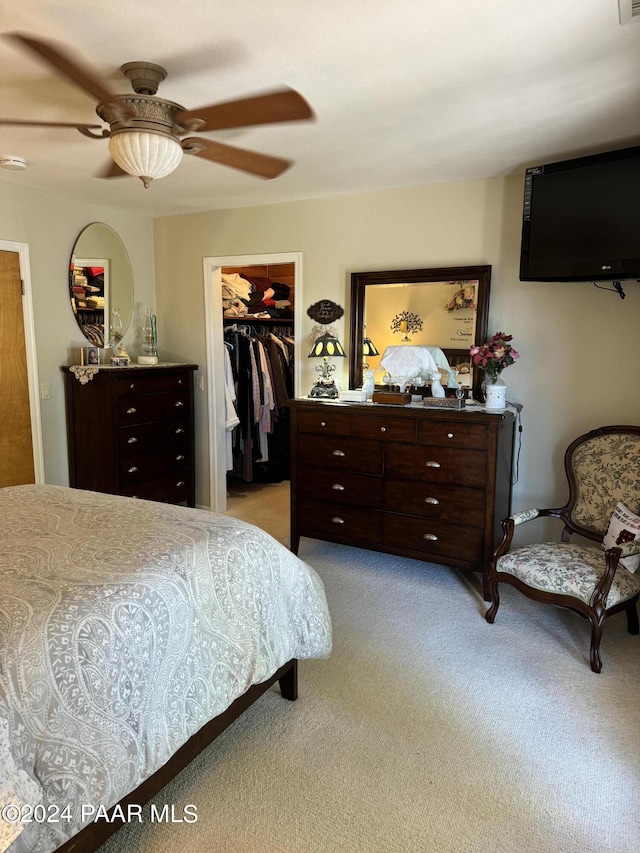 carpeted bedroom featuring a closet, a spacious closet, and ceiling fan