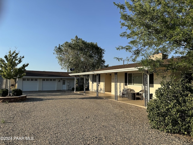 ranch-style house with a porch and a garage