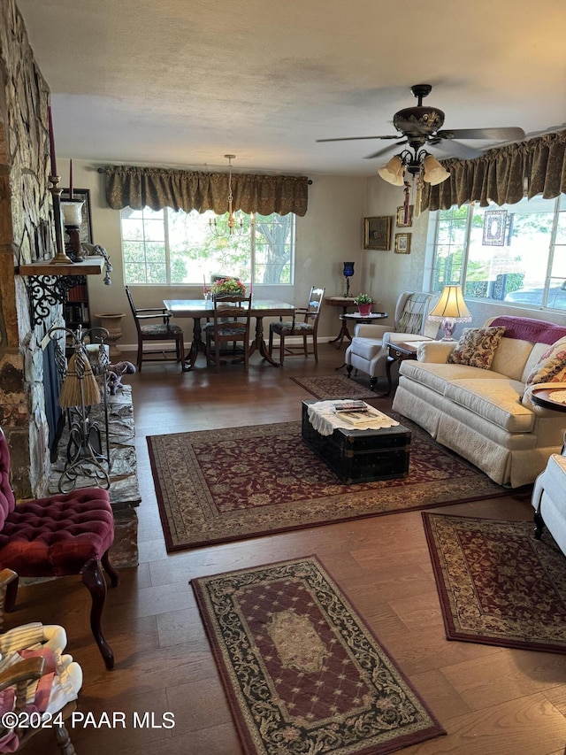 living room with a fireplace, wood-type flooring, and ceiling fan