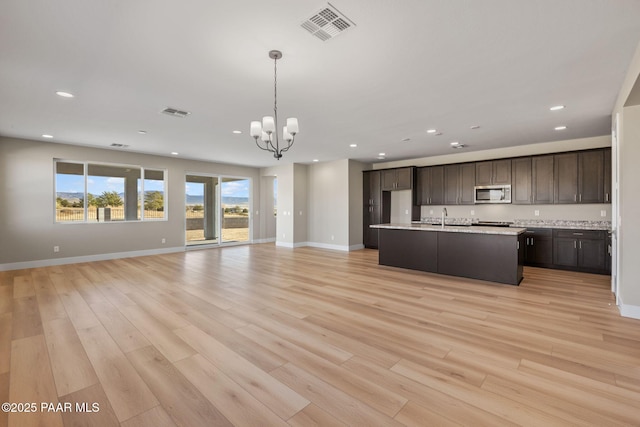 kitchen featuring sink, light hardwood / wood-style flooring, a chandelier, decorative light fixtures, and dark brown cabinets