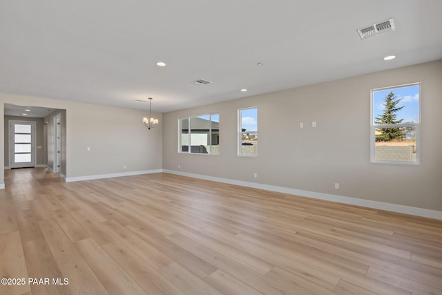 unfurnished room with light hardwood / wood-style flooring and an inviting chandelier