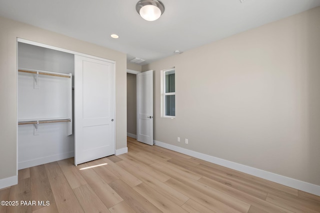 unfurnished bedroom with light wood-type flooring and a closet