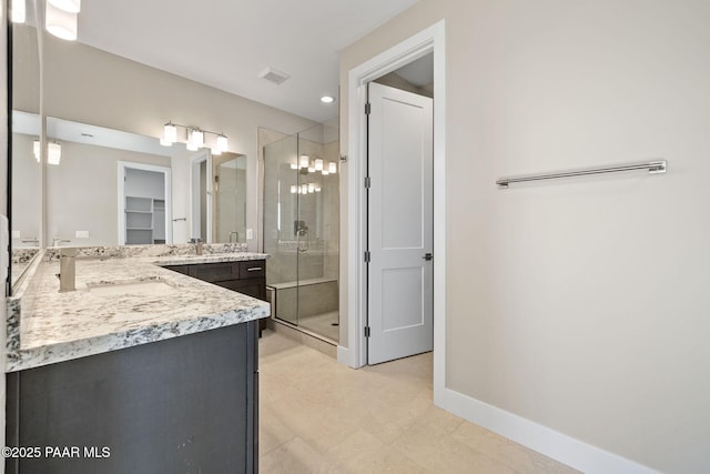 bathroom featuring vanity and a shower with door