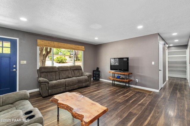 living room with dark hardwood / wood-style floors, a barn door, and a textured ceiling