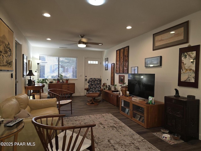 living room with dark hardwood / wood-style flooring and ceiling fan