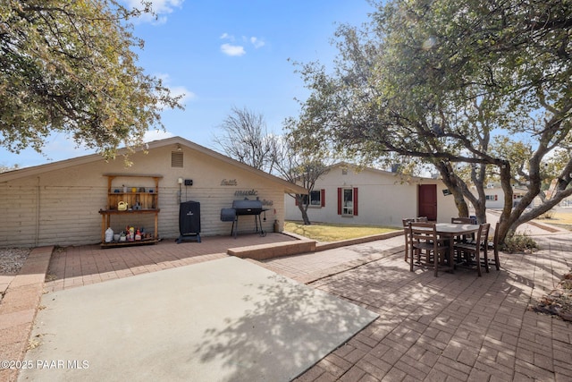 rear view of house with outdoor dining space and a patio area