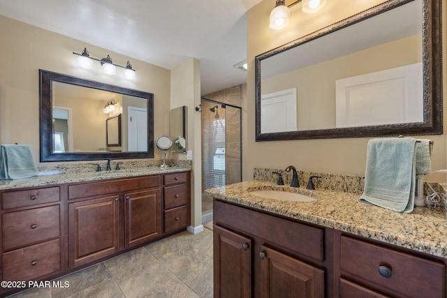 full bath featuring a shower stall, two vanities, and a sink