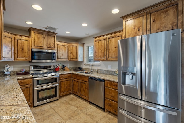 kitchen with visible vents, appliances with stainless steel finishes, and brown cabinetry