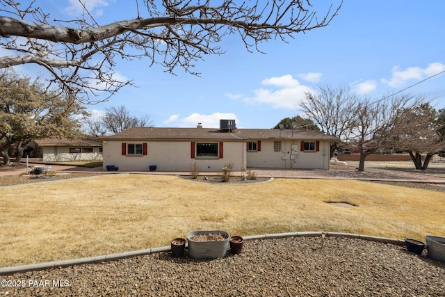 back of house with central AC unit and a lawn