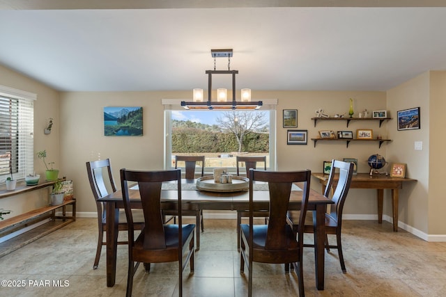 dining area featuring a healthy amount of sunlight, baseboards, and a chandelier