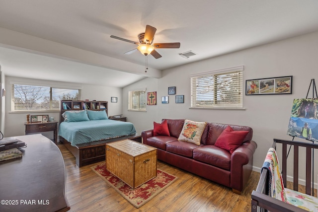 bedroom with visible vents, multiple windows, lofted ceiling, and wood-type flooring