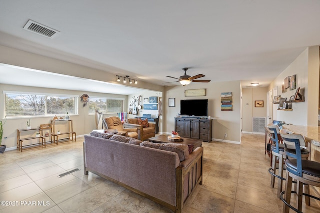 living room featuring light tile patterned flooring, a ceiling fan, and visible vents